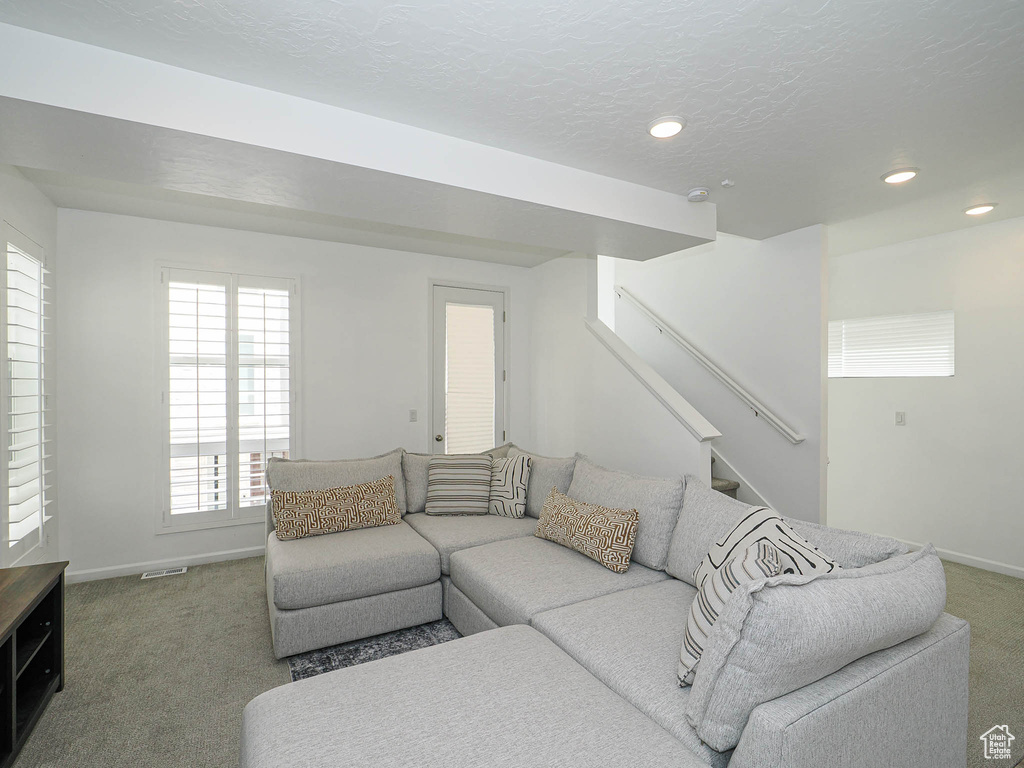 Carpeted living room featuring stairway and recessed lighting