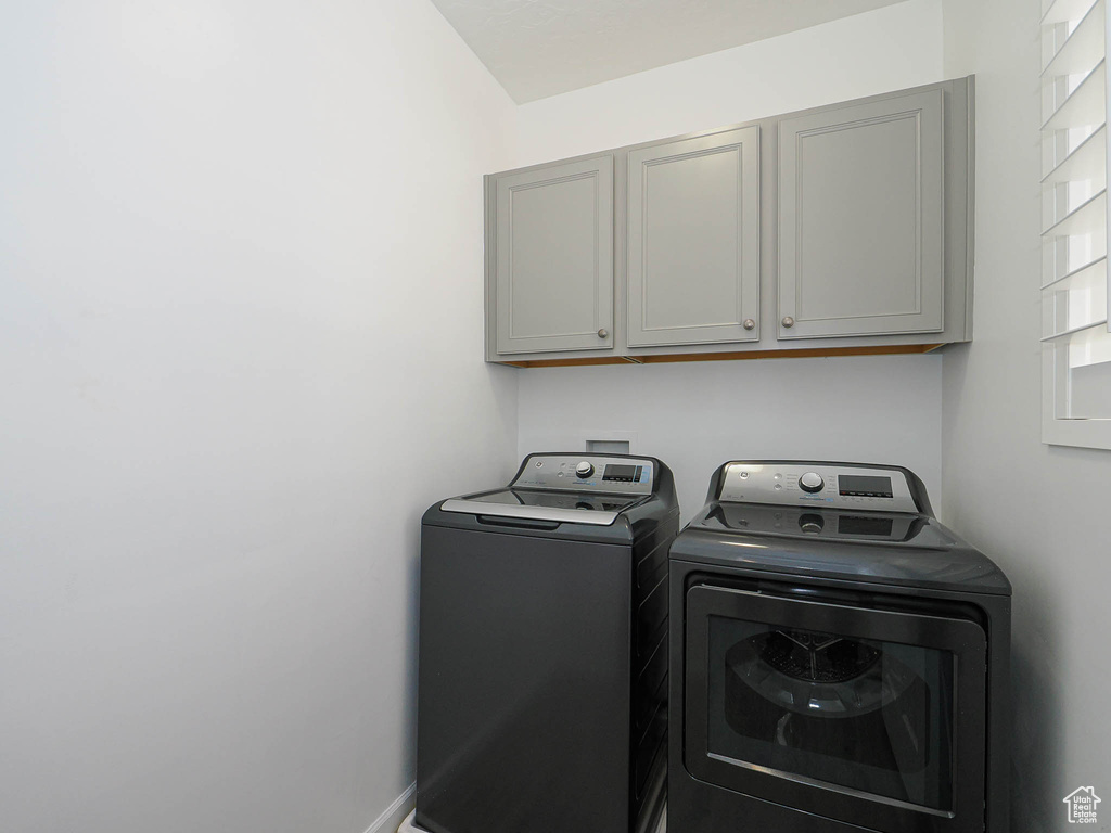 Laundry area with cabinet space and washer and clothes dryer