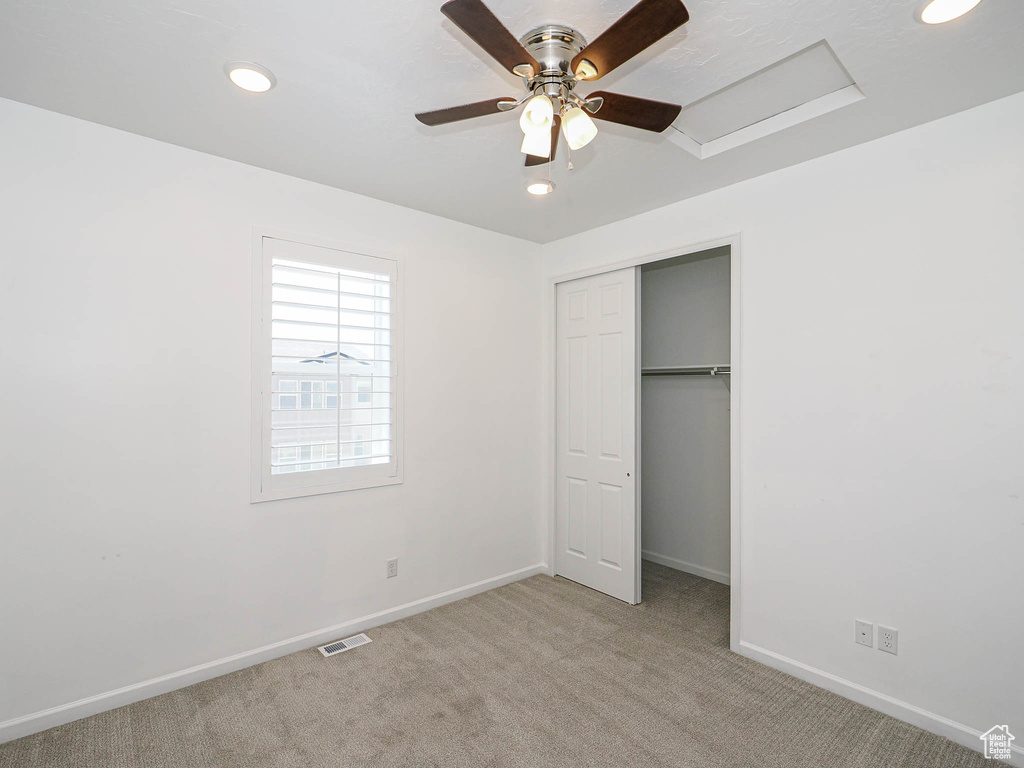 Unfurnished bedroom with light carpet, recessed lighting, a closet, and a ceiling fan