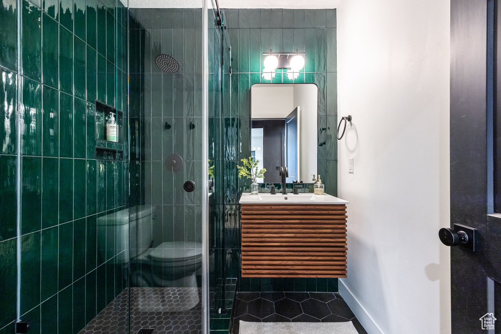 Full bath with a shower stall, vanity, and tile patterned flooring