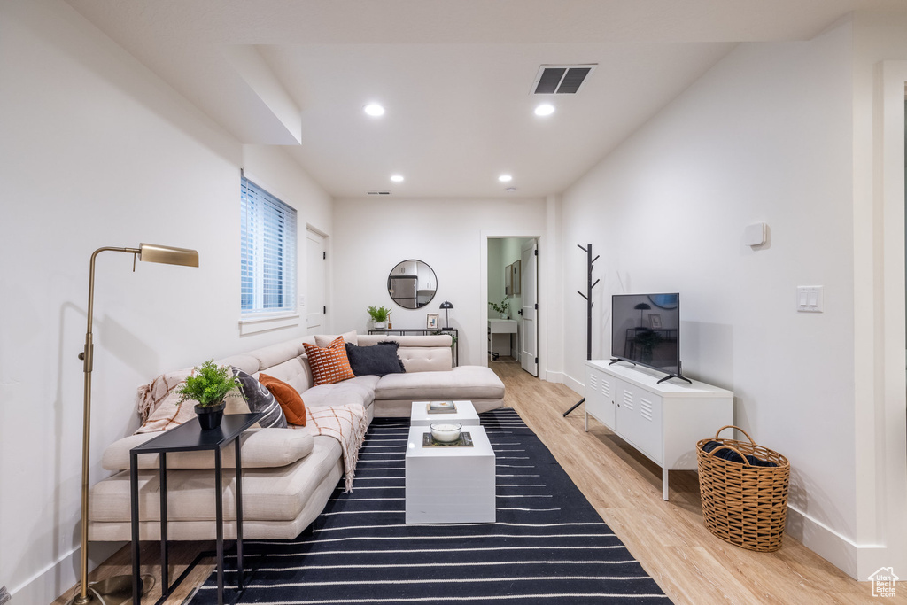 Living area with light wood-style floors and recessed lighting