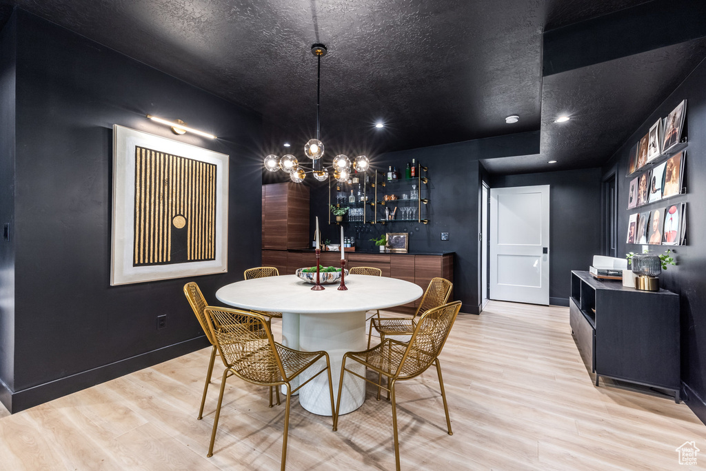 Dining room with light wood-type flooring, a chandelier, and recessed lighting