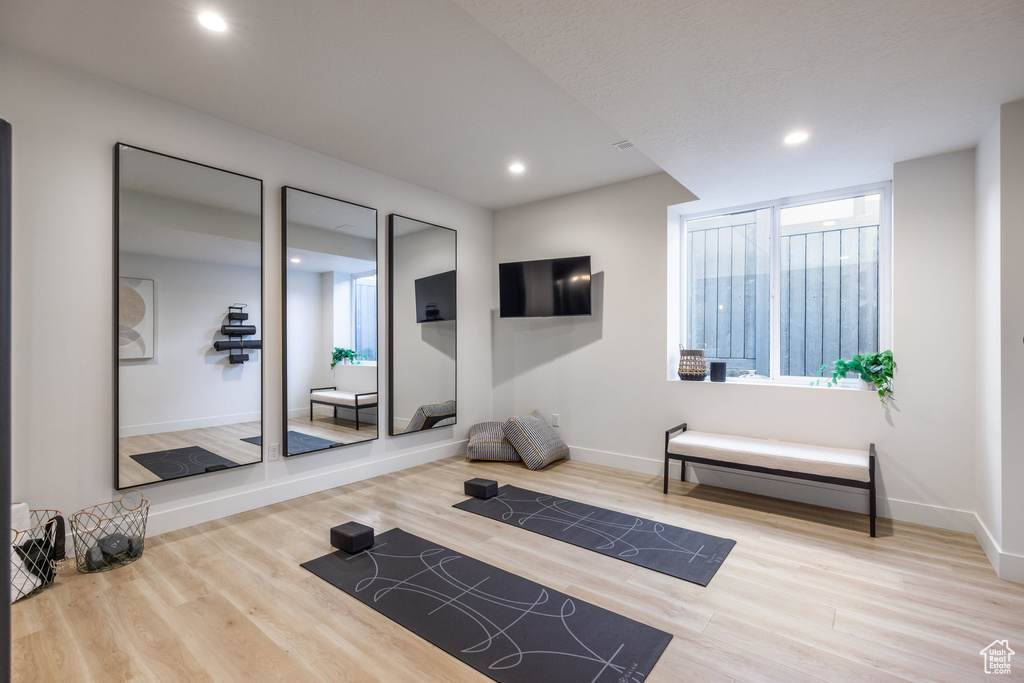Exercise room with plenty of natural light, wood finished floors, and recessed lighting