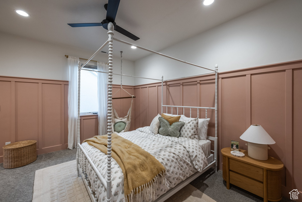 Carpeted bedroom featuring a decorative wall, wainscoting, recessed lighting, and a ceiling fan