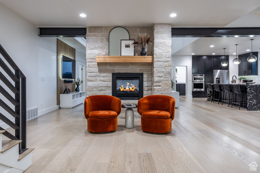 Living area featuring stairway, light wood-style floors, a fireplace, and recessed lighting