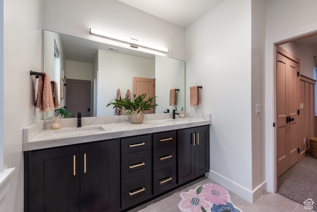 Full bath with double vanity and tile patterned flooring