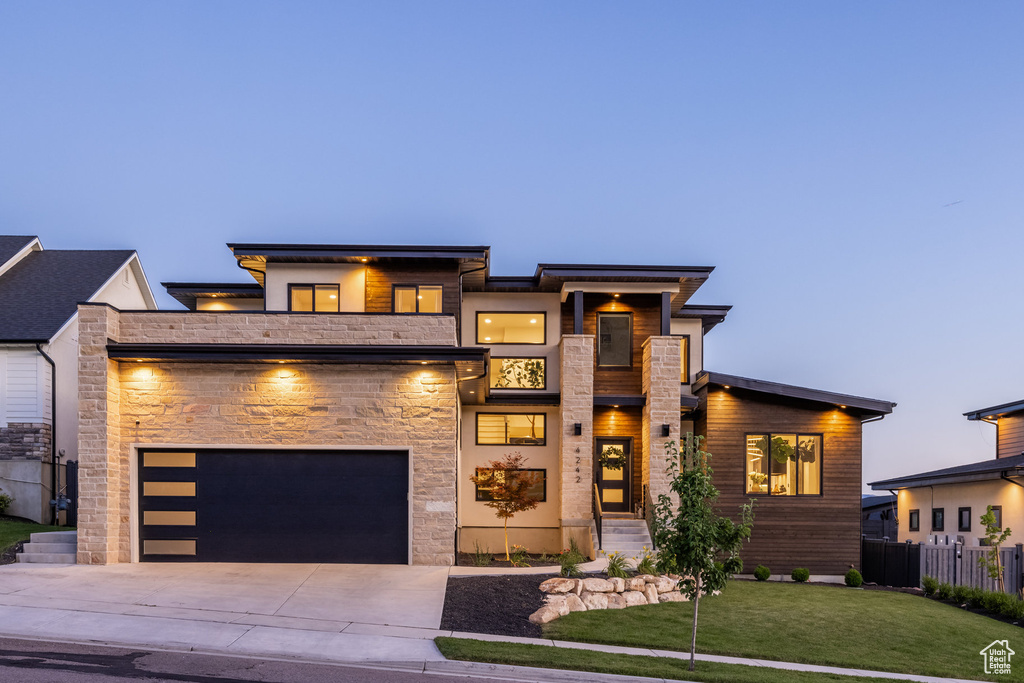 View of front of house with driveway and stone siding