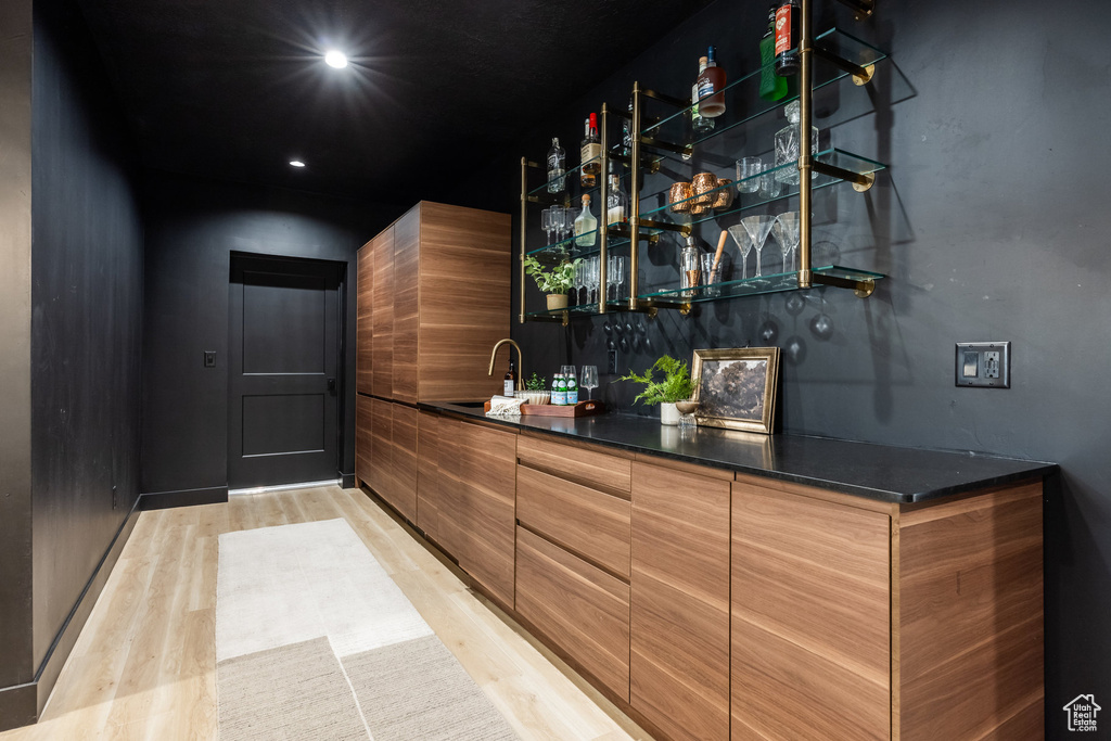 Indoor wet bar featuring light wood-type flooring and recessed lighting