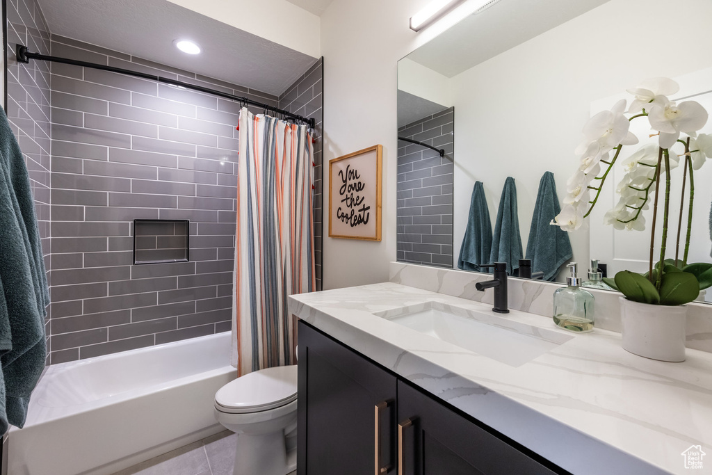 Bathroom featuring vanity, shower / bathtub combination with curtain, tile patterned flooring, and recessed lighting