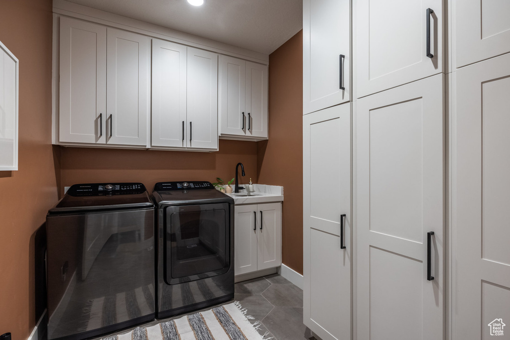 Laundry room featuring independent washer and dryer and cabinet space