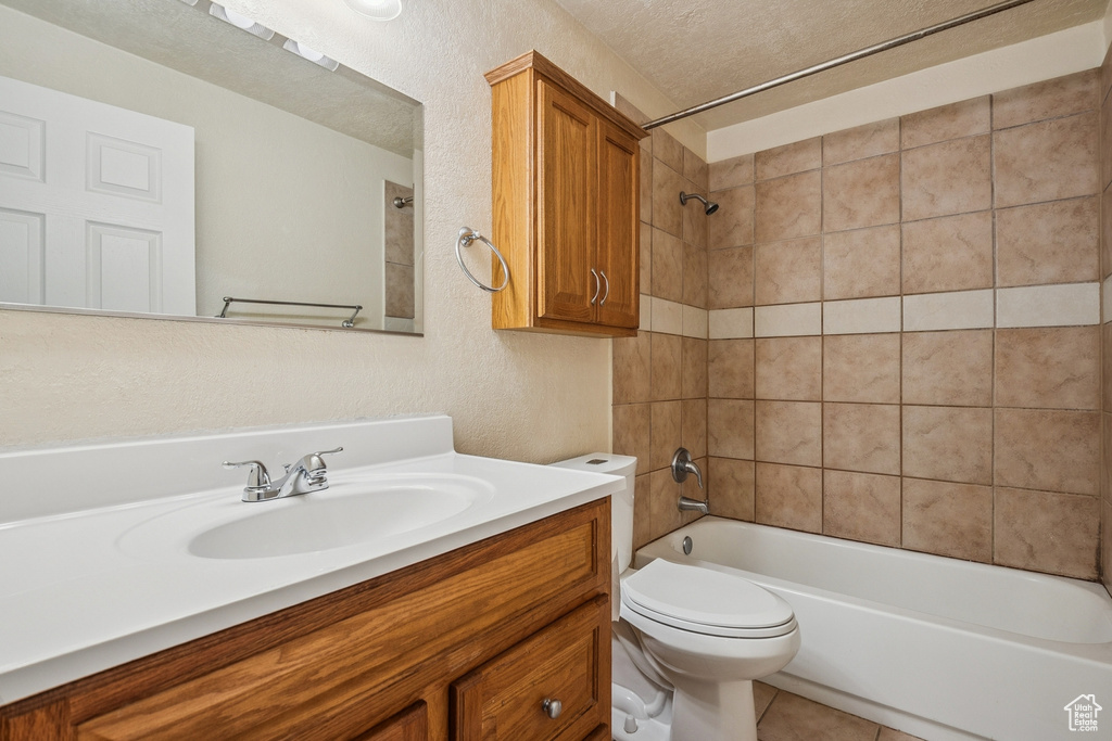 Full bath featuring vanity, tub / shower combination, a textured ceiling, and tile patterned flooring