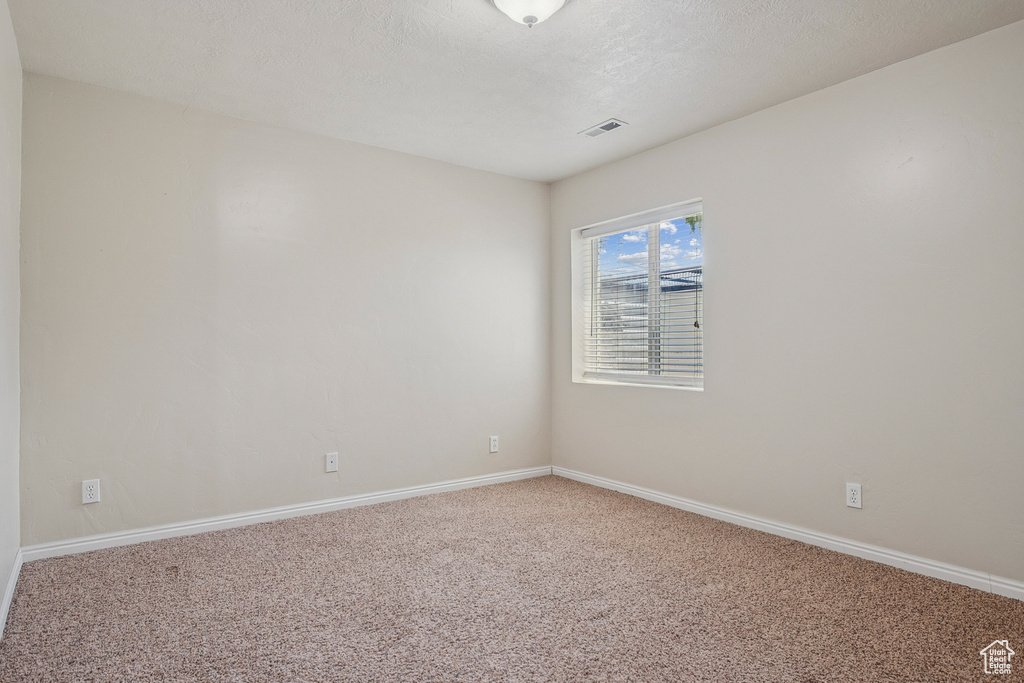 Empty room with carpet and baseboards