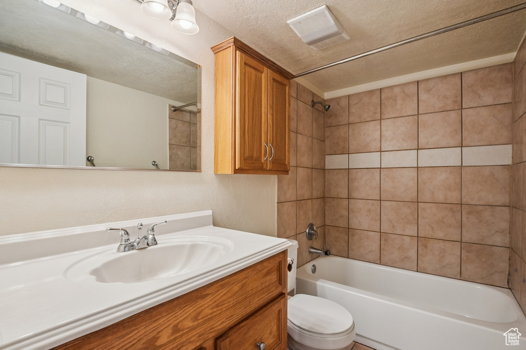Full bathroom with vanity, bathtub / shower combination, and a textured ceiling