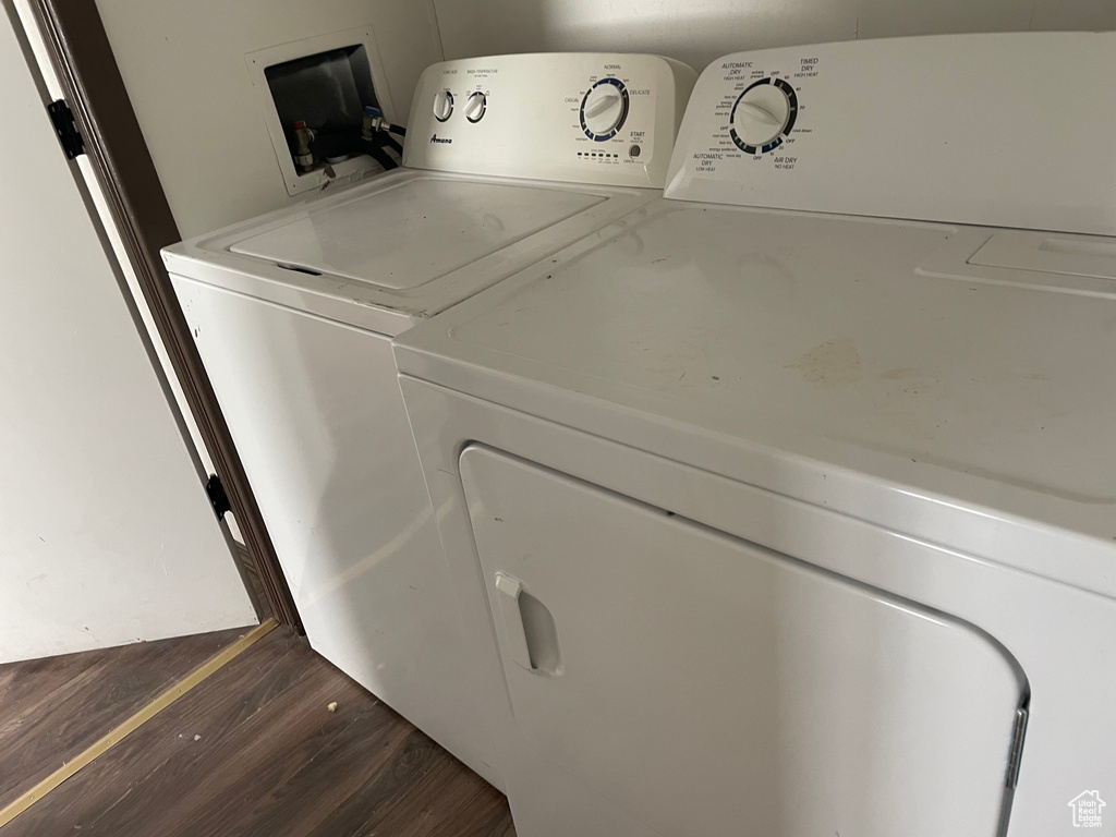 Washroom with separate washer and dryer and dark wood-type flooring