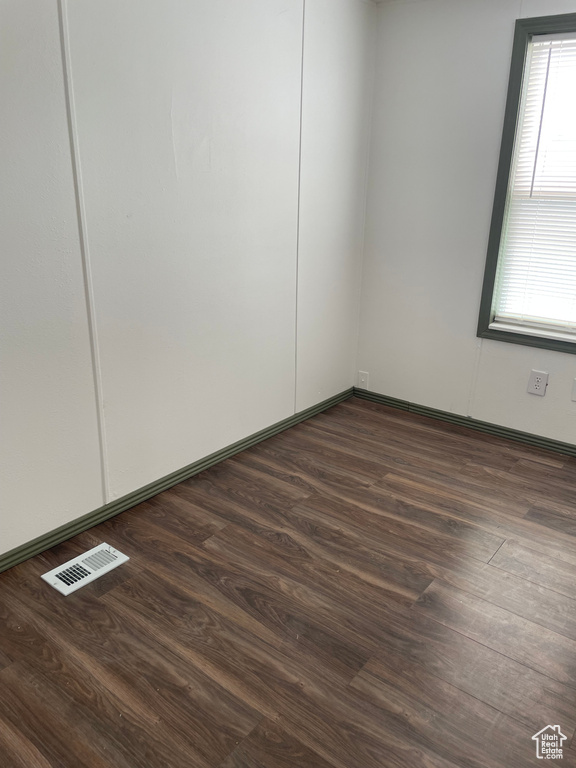 Spare room with plenty of natural light and dark wood-style floors