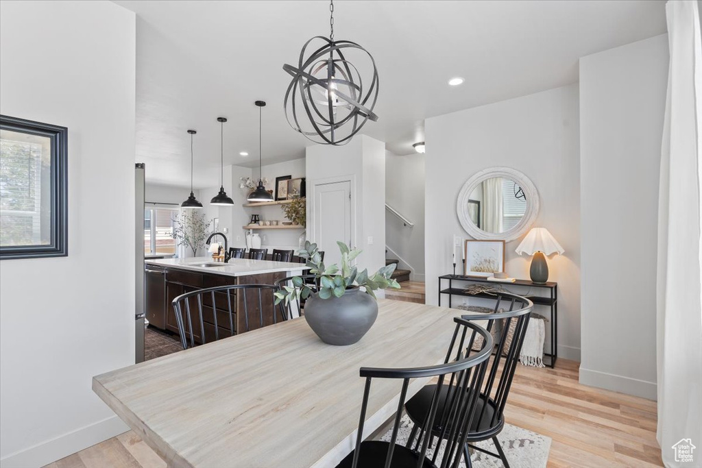 Dining area featuring stairs, a chandelier, light wood-type flooring, and recessed lighting