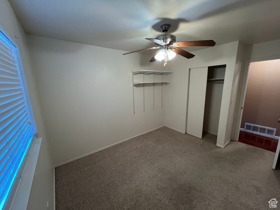 Unfurnished bedroom featuring carpet flooring, a closet, and ceiling fan