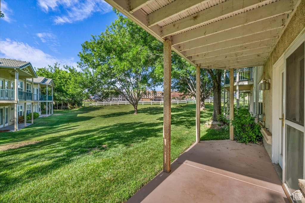 View of grassy yard with a patio area