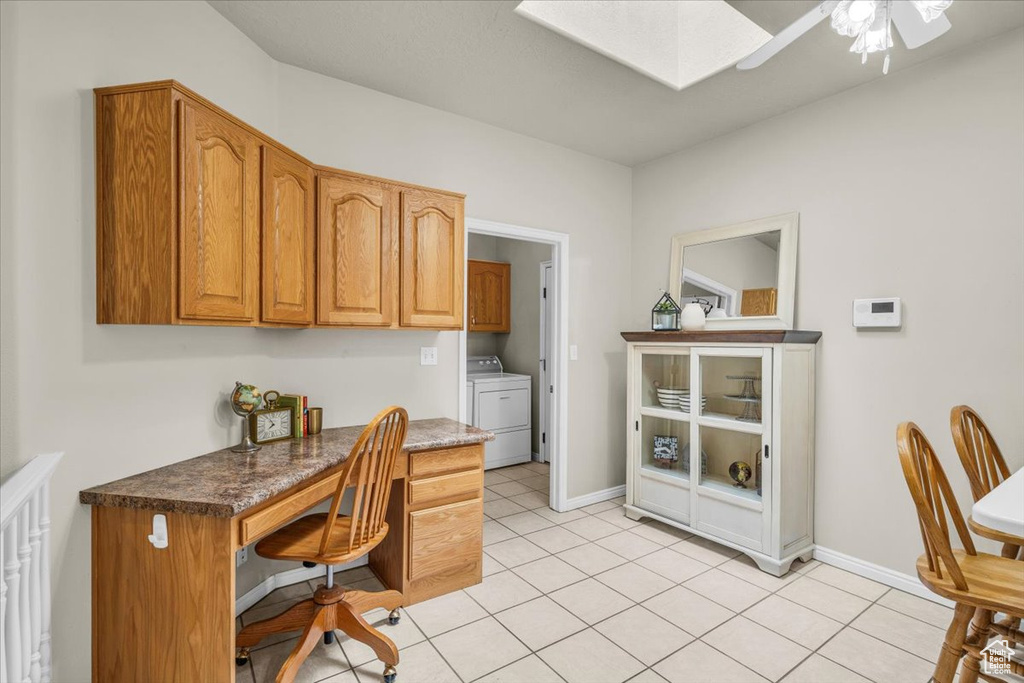 Office space with washer / dryer, a skylight, a ceiling fan, and light tile patterned floors