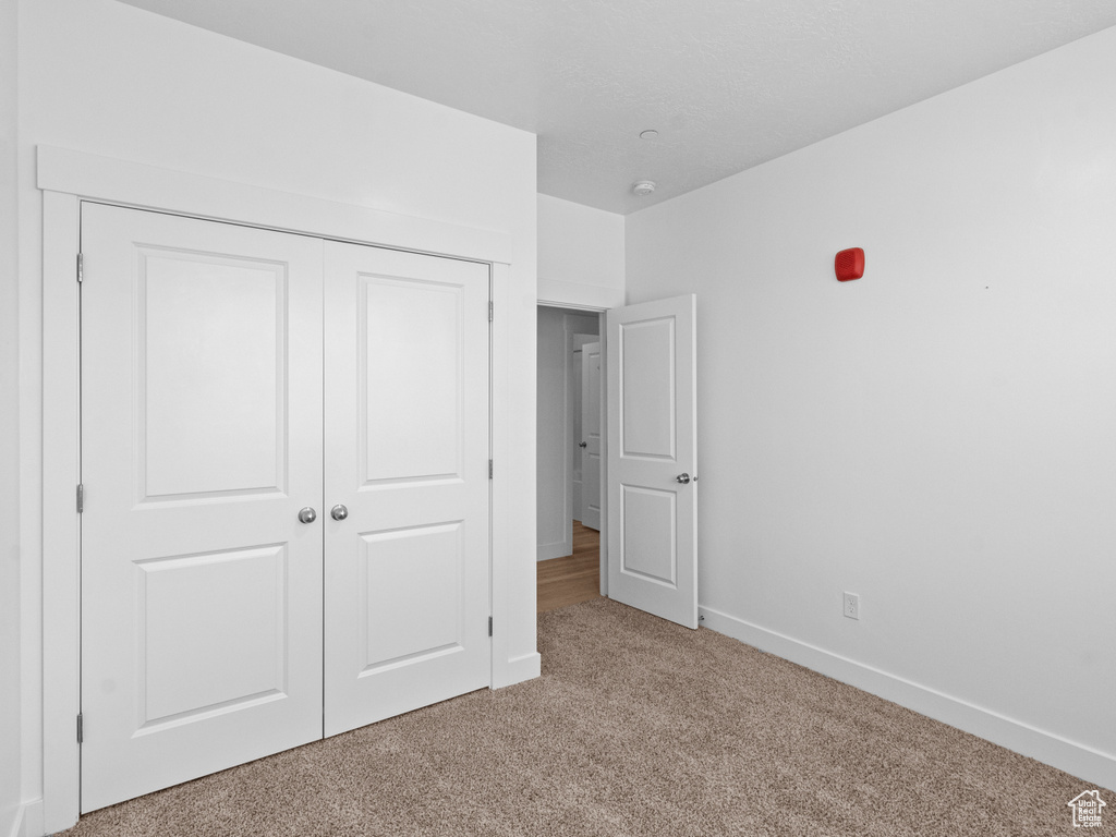Unfurnished bedroom with carpet flooring and a closet