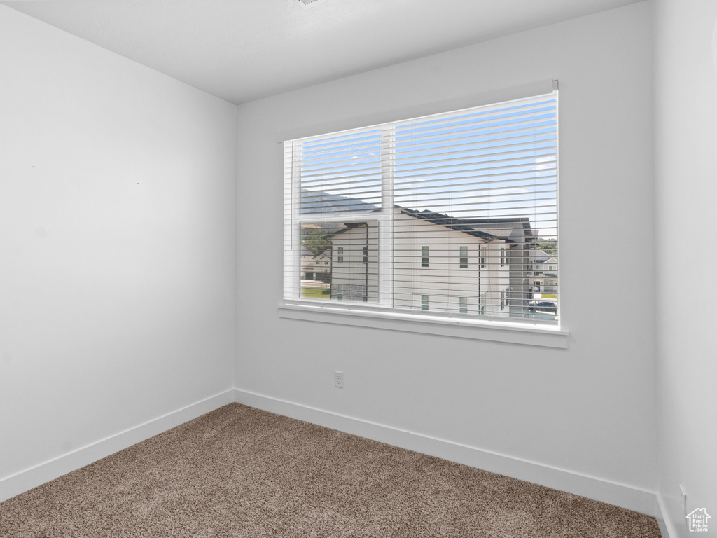 Unfurnished room featuring carpet flooring and baseboards