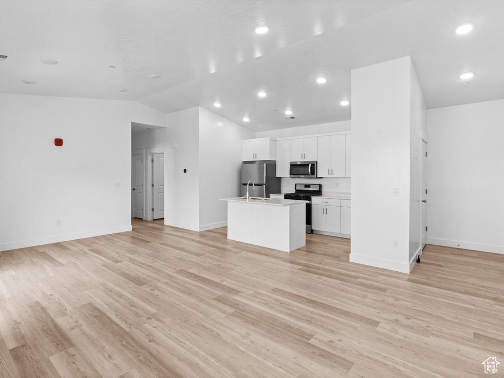Unfurnished living room with light wood-style flooring, lofted ceiling, and recessed lighting