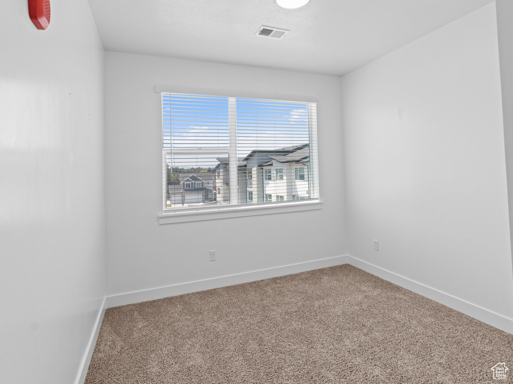 Unfurnished room featuring carpet and baseboards