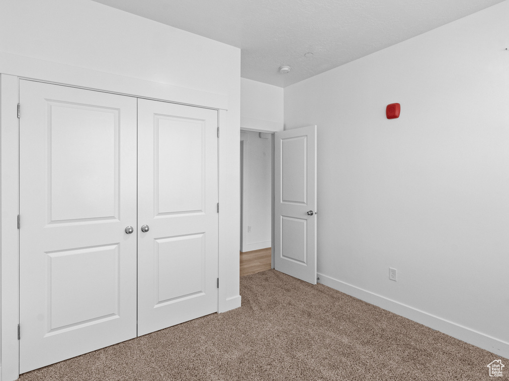 Unfurnished bedroom featuring carpet and a closet