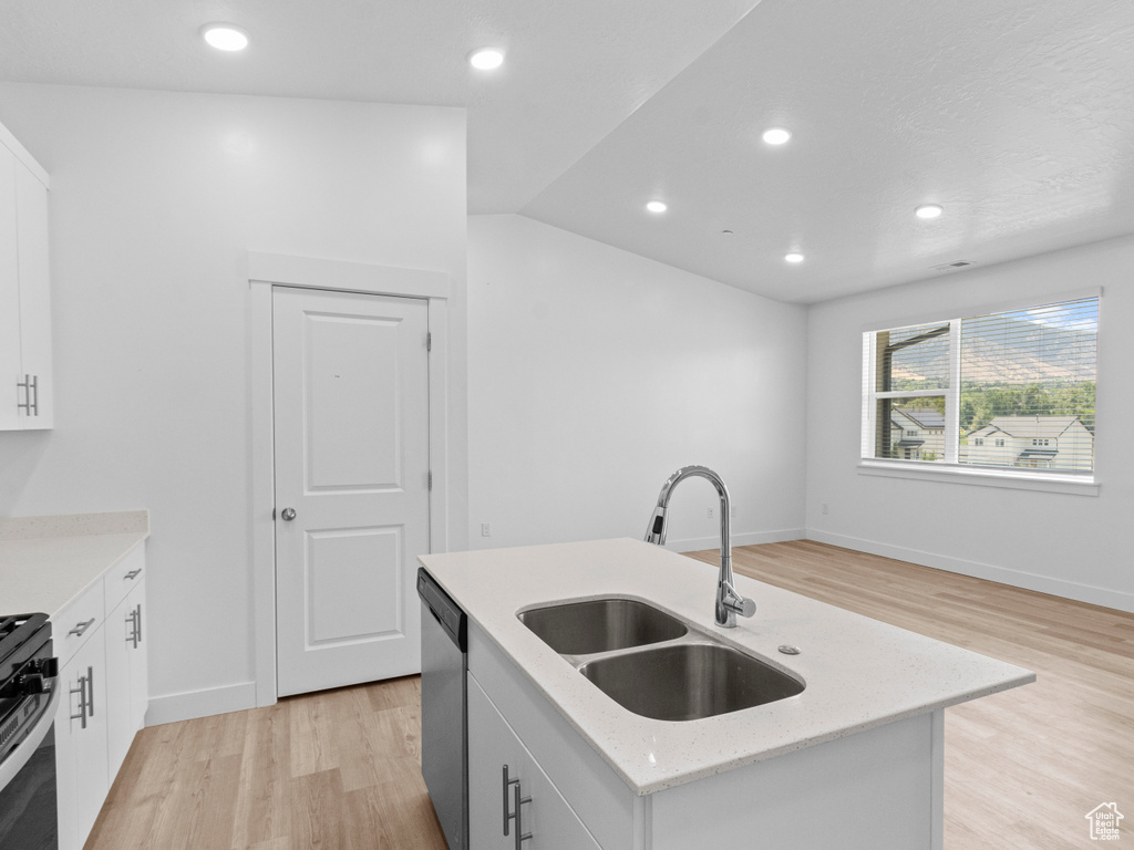 Kitchen with appliances with stainless steel finishes, light wood-type flooring, white cabinetry, a kitchen island with sink, and recessed lighting