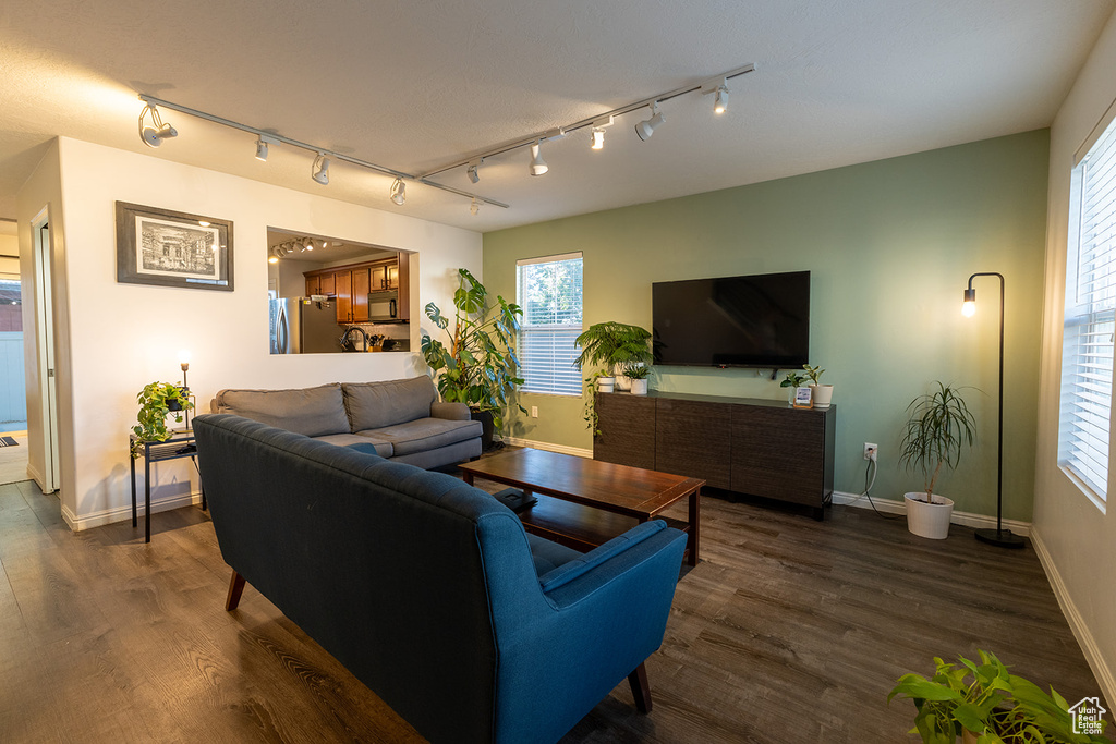 Living area with track lighting and dark wood finished floors