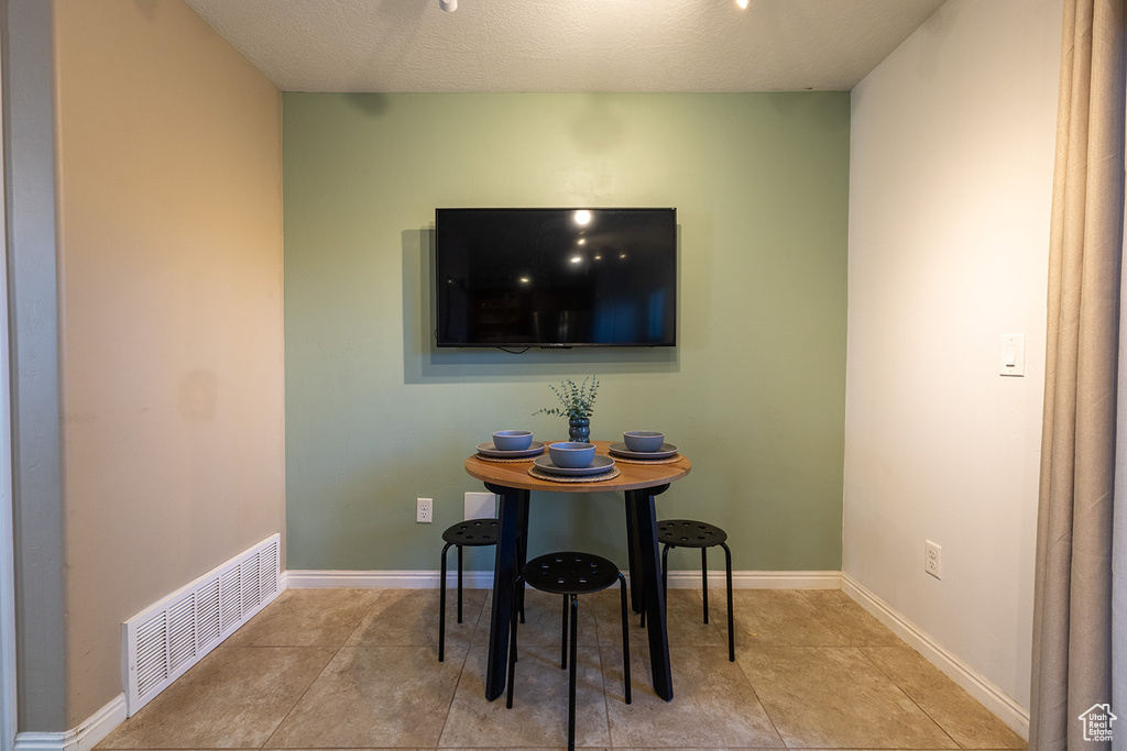 Dining room with tile patterned flooring and a textured ceiling