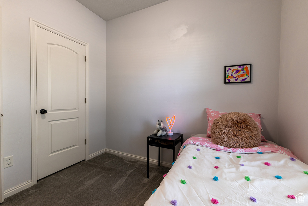 Bedroom with dark carpet and baseboards