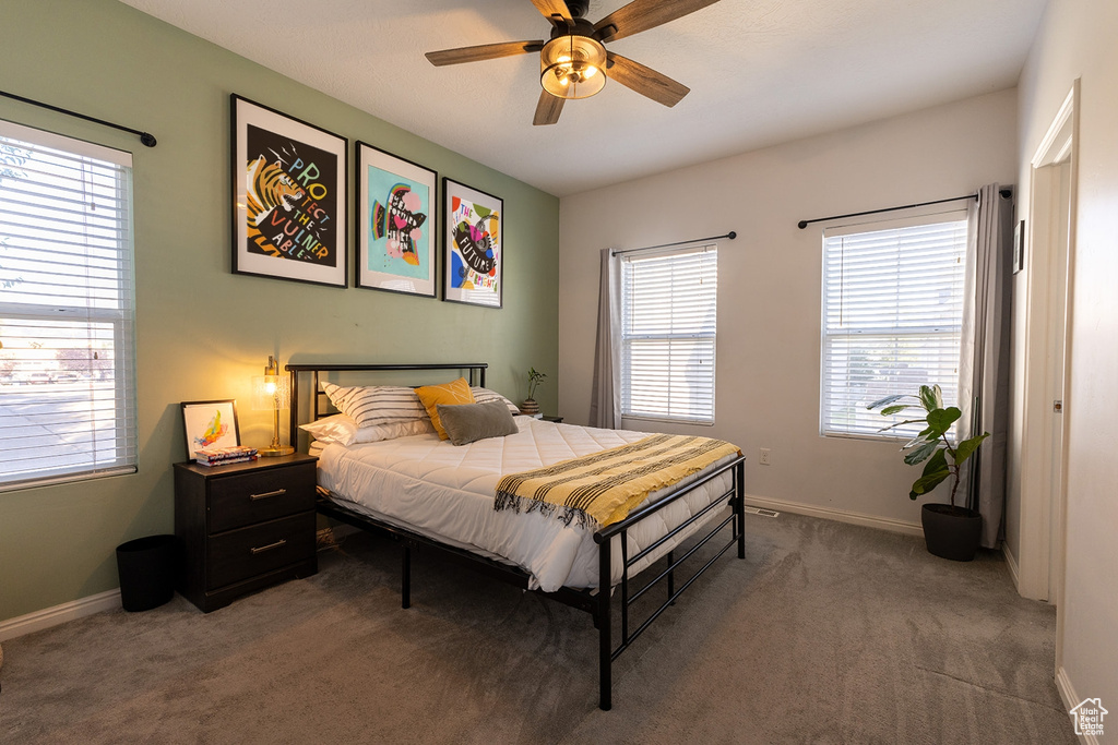 Carpeted bedroom with baseboards and ceiling fan