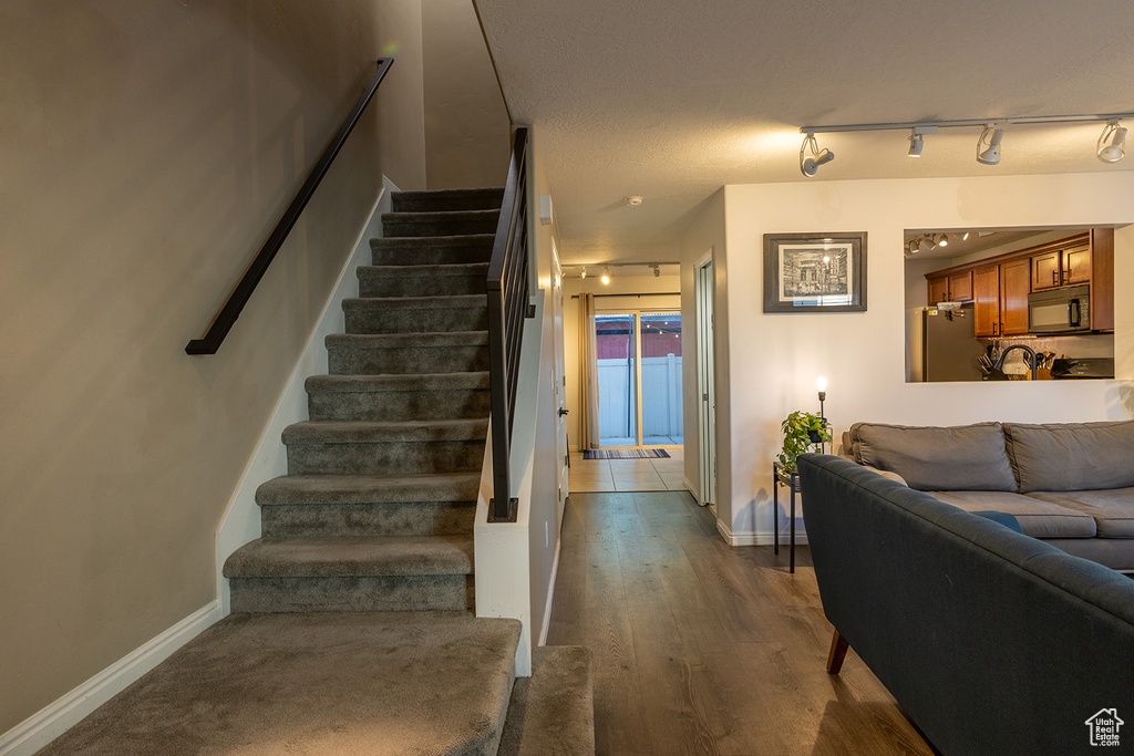Staircase with rail lighting and wood finished floors