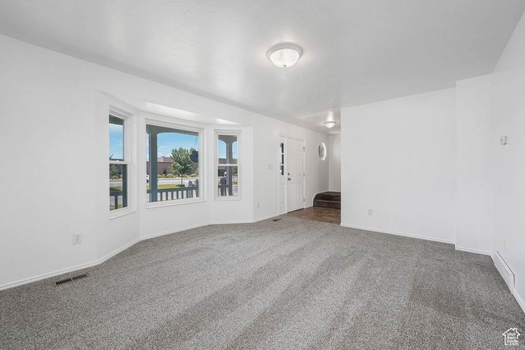 Empty room featuring carpet flooring and stairway