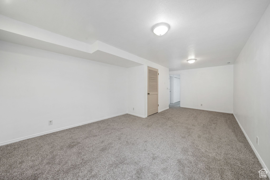 Basement featuring carpet flooring and baseboards