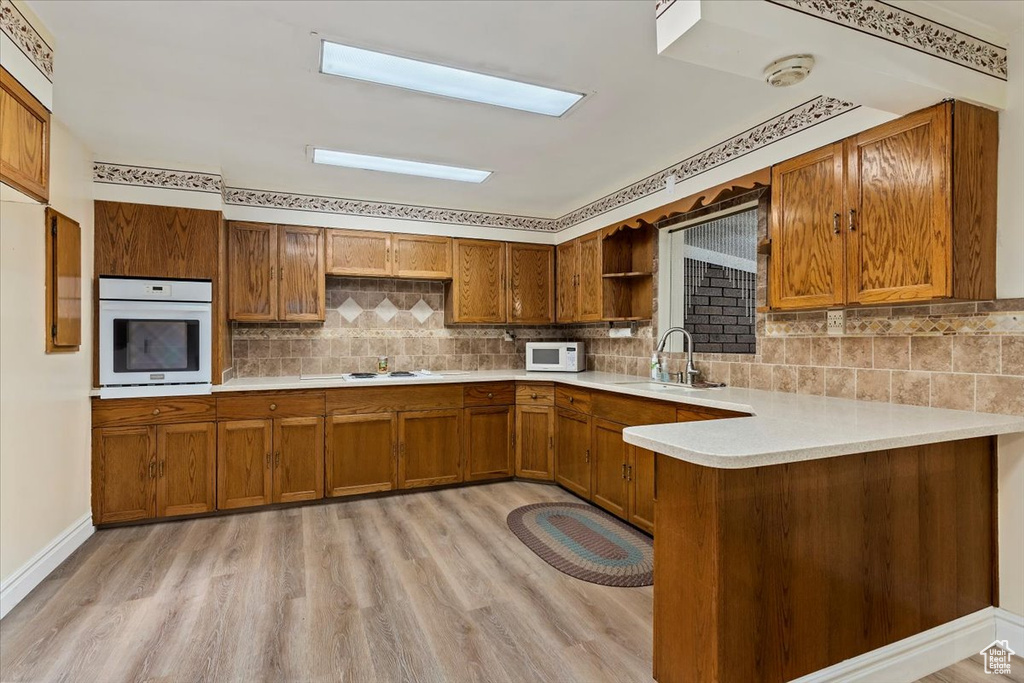Kitchen with white appliances, brown cabinets, and open shelves