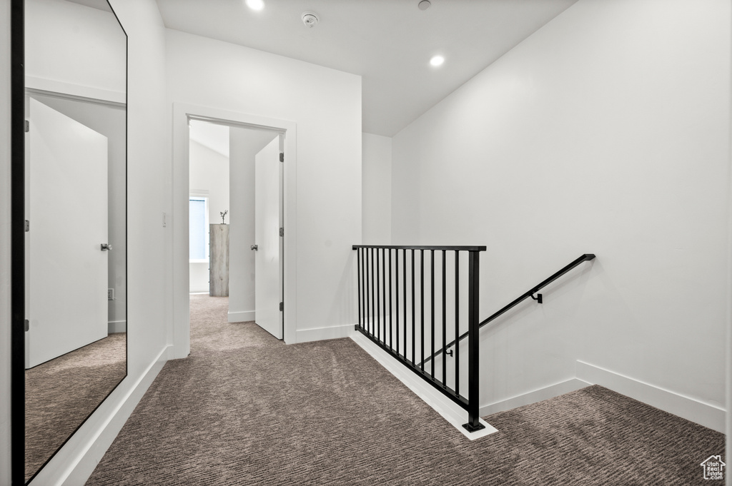 Hallway featuring an upstairs landing, carpet flooring, and recessed lighting