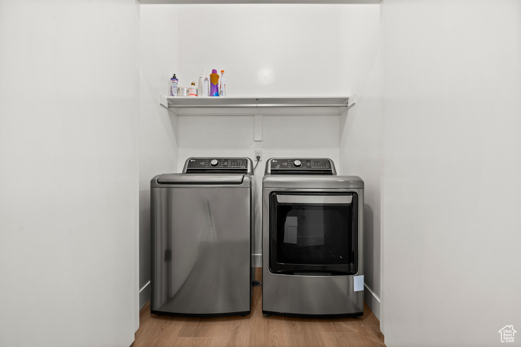 Laundry room with separate washer and dryer and wood finished floors