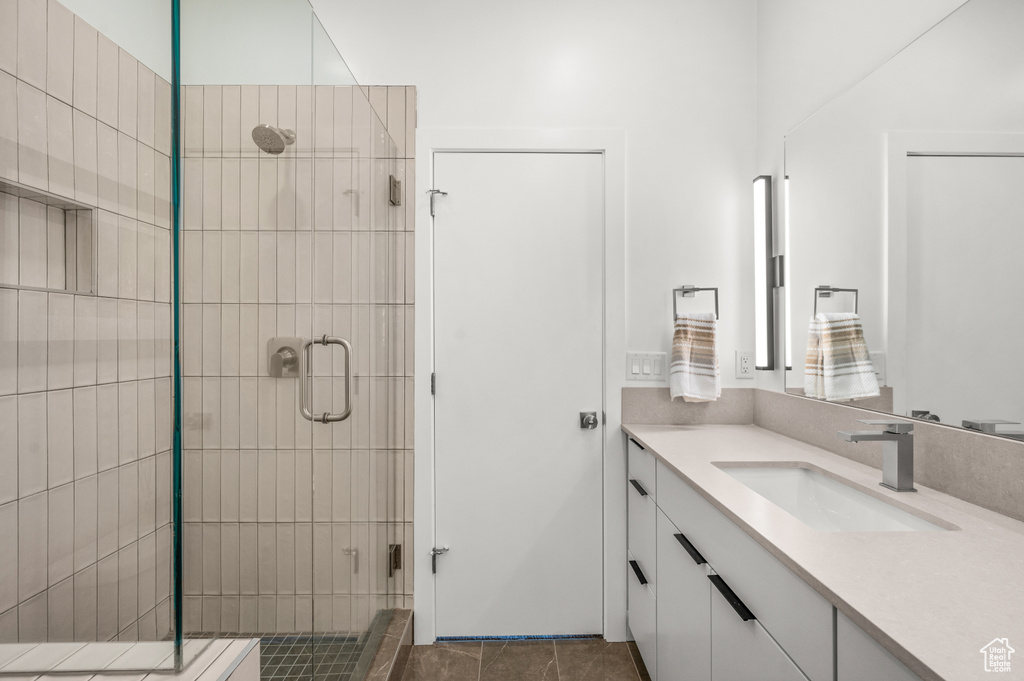 Bathroom featuring vanity, a stall shower, and tile patterned flooring