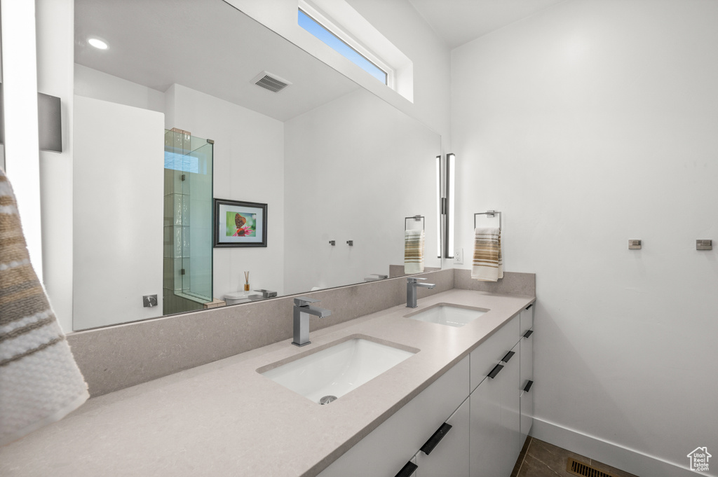 Bathroom with double vanity and baseboards