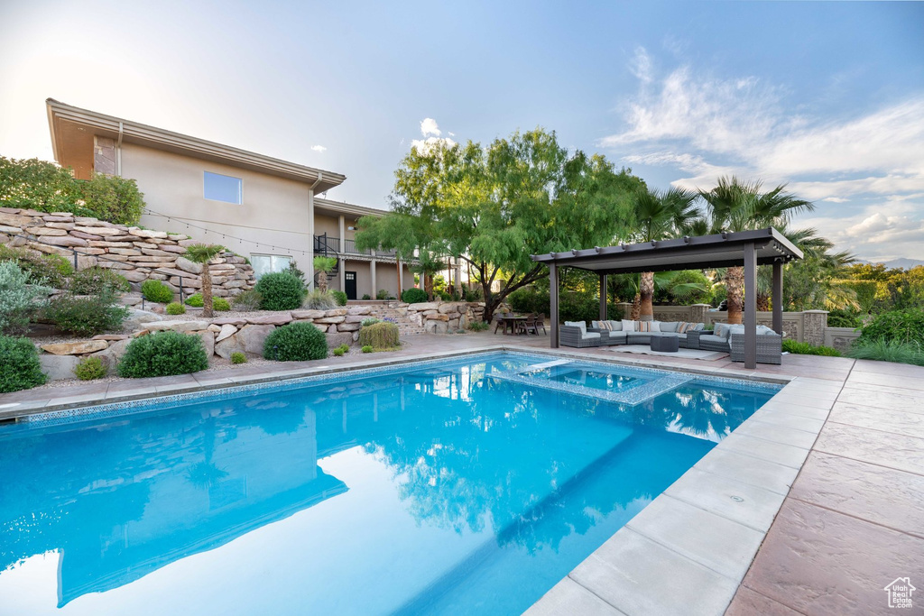 View of pool featuring an outdoor living space, a patio area, and a pool with connected hot tub