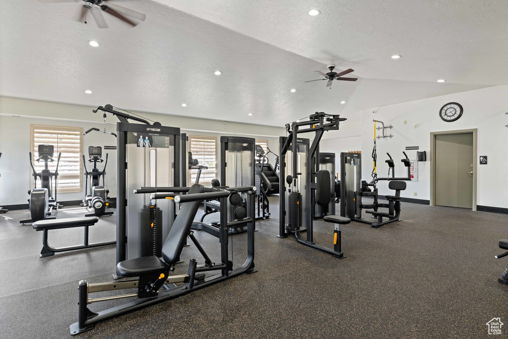 Gym with a ceiling fan, plenty of natural light, vaulted ceiling, recessed lighting, and a textured ceiling