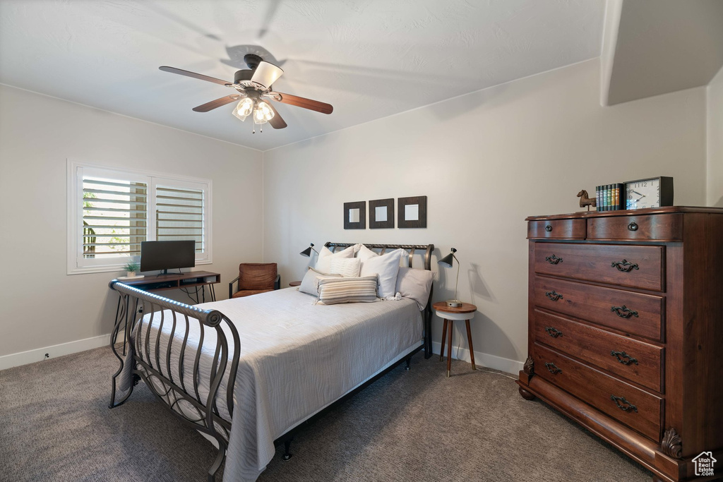 Carpeted bedroom featuring baseboards and a ceiling fan