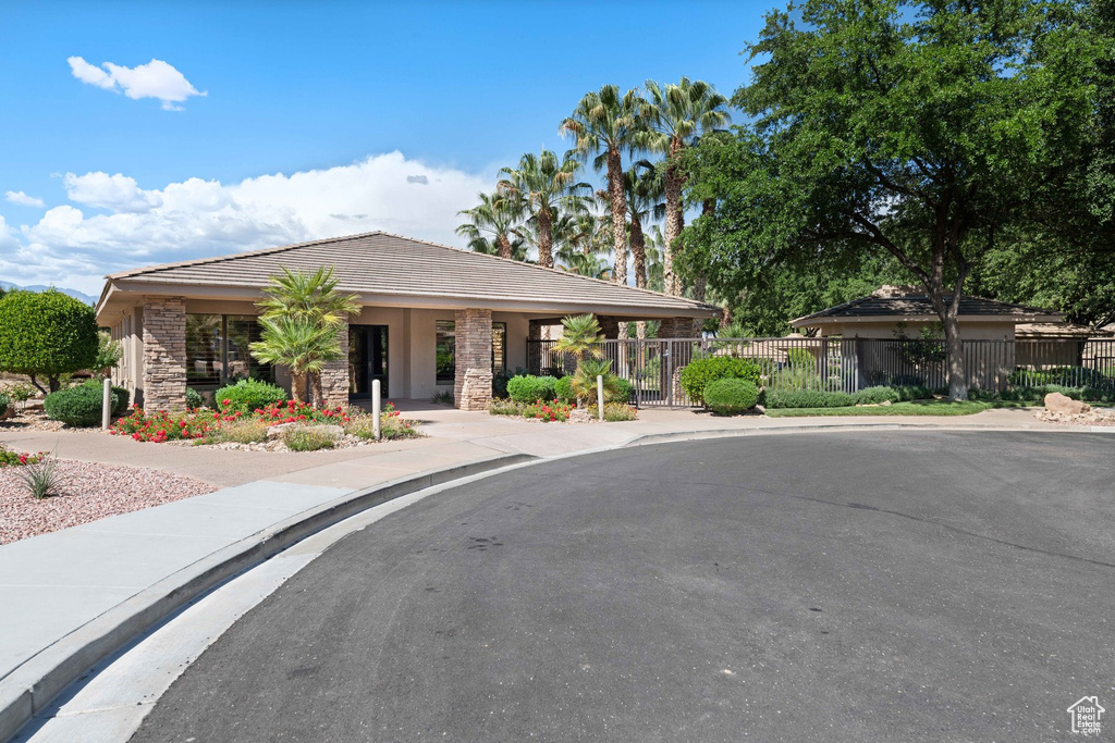 View of front of house featuring a tiled roof, stone siding, and stucco siding