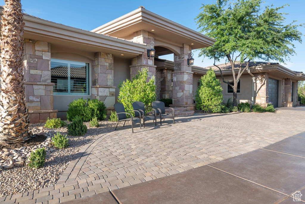 View of patio featuring a garage and decorative driveway