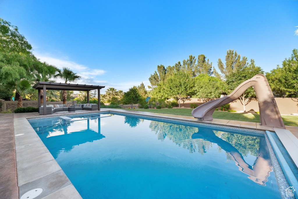 Swimming pool with an outdoor living space, a water slide, and a gazebo