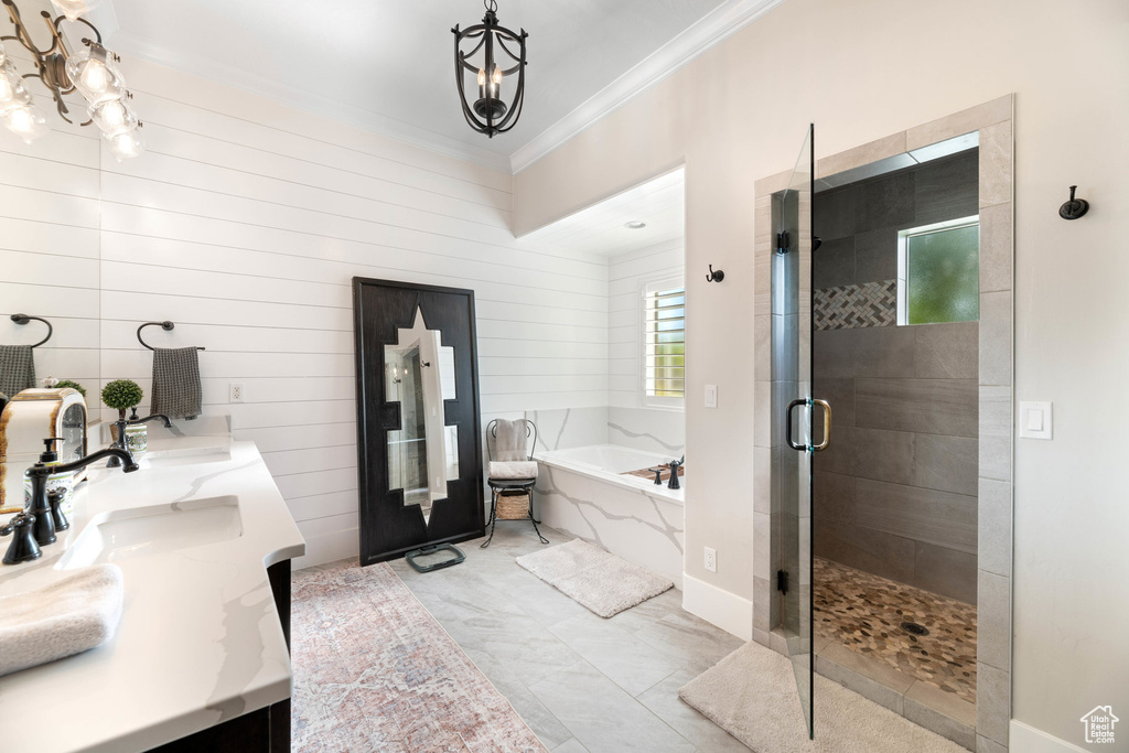 Full bath with crown molding, a bath, a shower stall, double vanity, and a chandelier