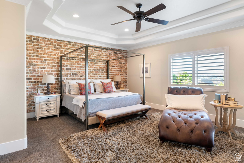 Bedroom with a raised ceiling, crown molding, recessed lighting, dark colored carpet, and a ceiling fan