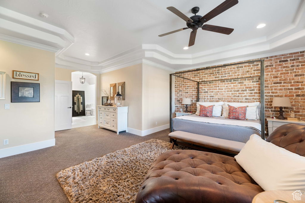 Carpeted bedroom with recessed lighting, brick wall, crown molding, a raised ceiling, and a ceiling fan